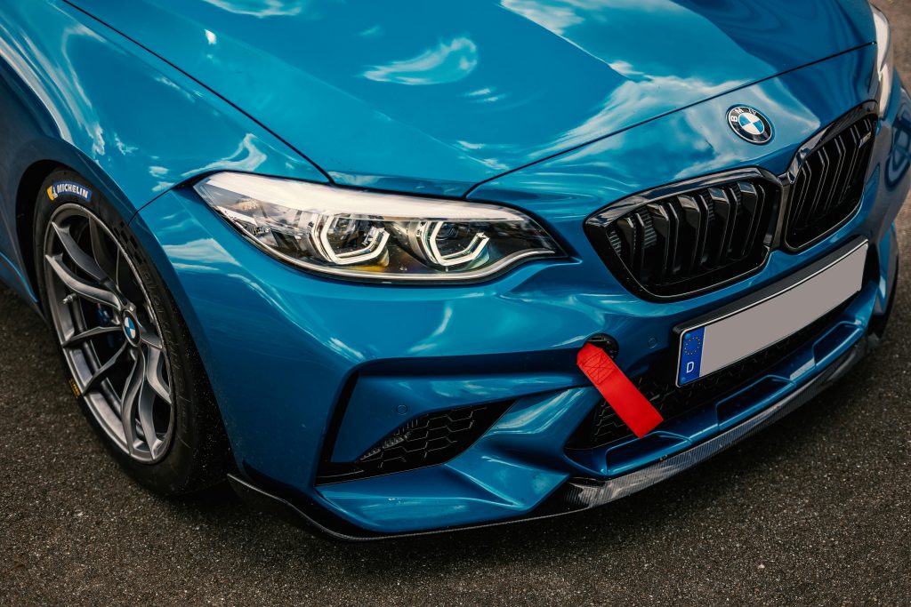 Close-up of a blue luxury sports car with shining headlights and sleek design.